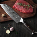Cuchillo Xinzuo Santoku de 7 pulgadas en acero Damasco con mango oscuro junto a un corte de carne y romero.