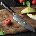 Cuchillo utilitario Xinzuo de 5 pulgadas en acero Damasco con mango de madera sobre tabla de picar y frutas.