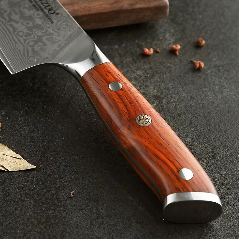 Primer plano del mango de madera de sándalo roja y hoja de acero de Damasco de un cuchillo de chef Xinzuo.