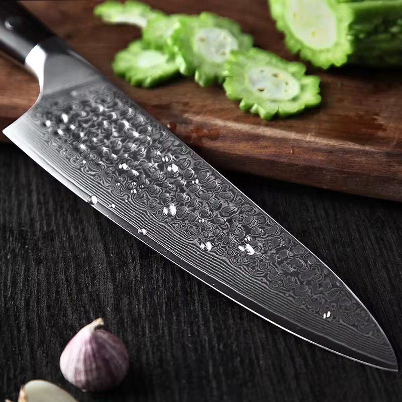 Cuchillo de chef XINZUO de acero de Damasco de 67 capas con gotas de agua sobre tabla de madera y vegetales.